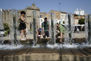 Una familia se refresca en una fuente en Plasencia, este martes. EFE/Eduardo Palomo