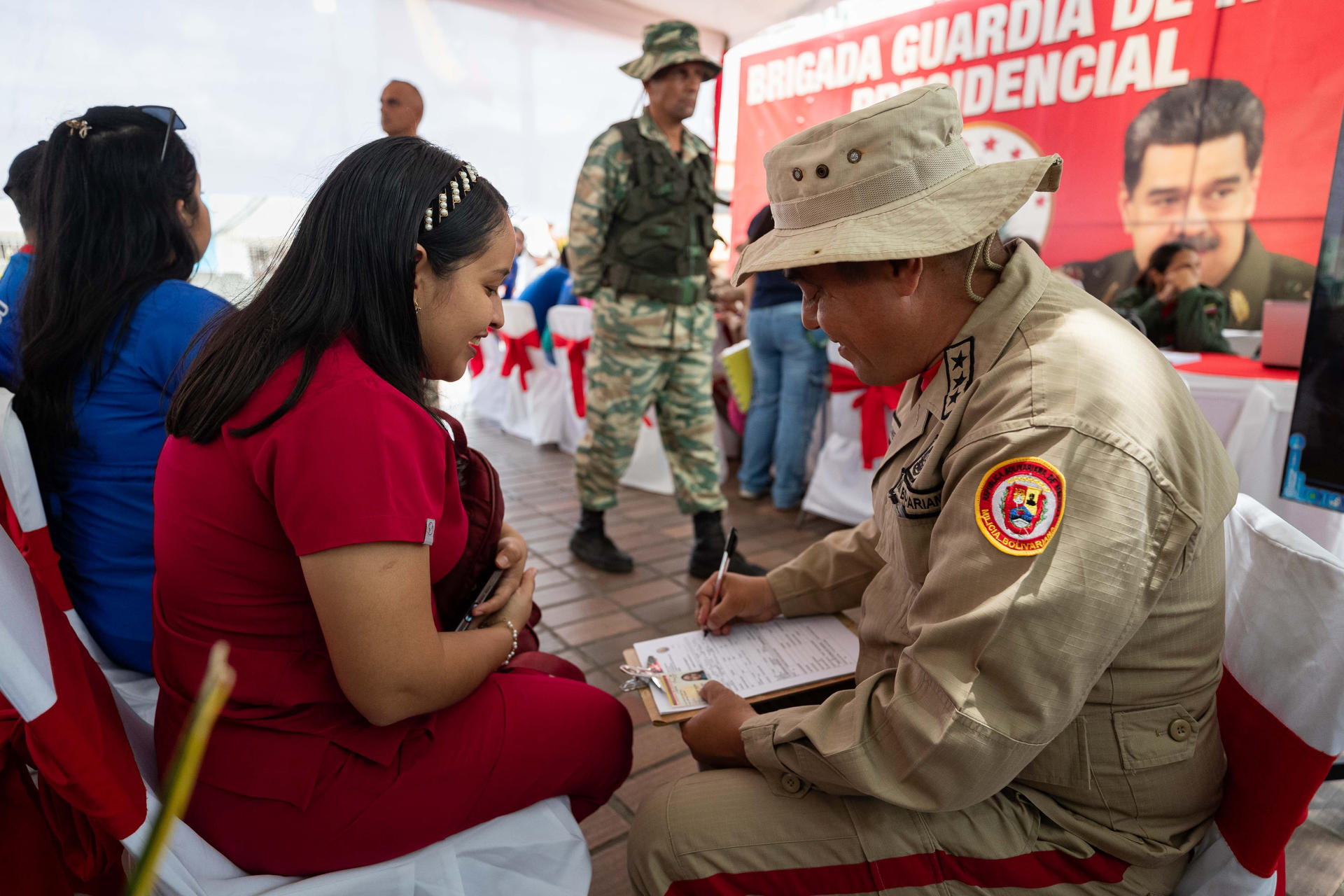 Un funcionario de la Milicia Bolivariana de Venezuela registra a una mujer durante una jornada de alistamiento este sábado, en Caracas (Venezuela). EFE/ Ronald Pena R