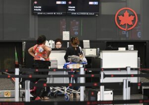 Un agente de Air Canada ayuda a los viajeros en el Aeropuerto Internacional Montreal-Trudeau, en Montreal (Canadá). EFE/EPA/GRAHAM HUGHES