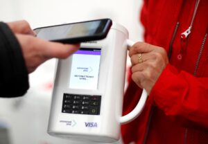 Foto archivo. Un viandante se dispone a hacer una donación con su móvil a una voluntaria de la Cruz Roja que dispone de una hucha de cuestación 'contactless' durante la celebración del Día de la Banderita. EFE/Villar López