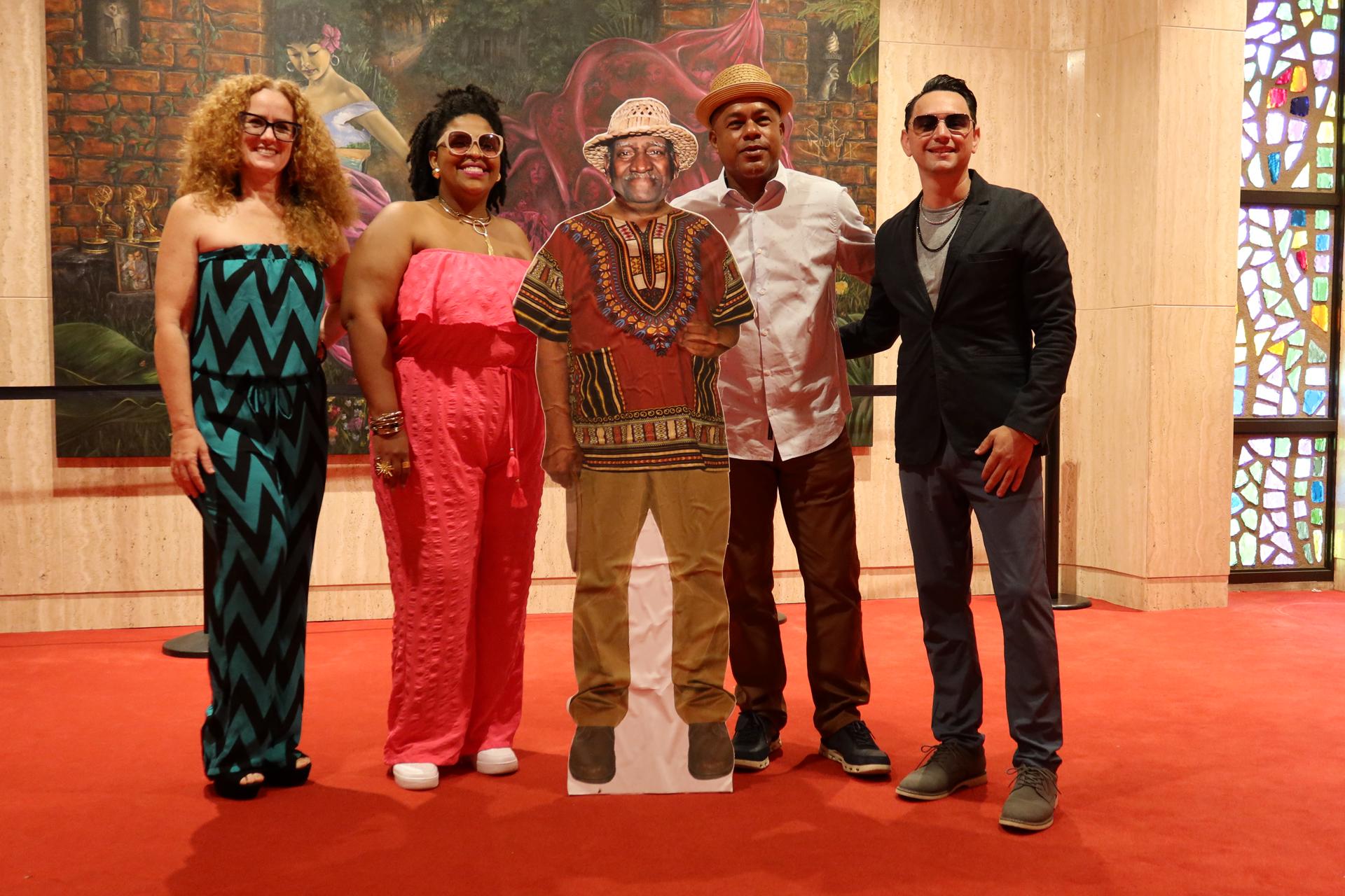 Desde la izquierda, los artistas Michelle Brava; Chamir Bonano; Ángel 'Papote' Alvarado y Willito Otero, posan junto a la imagen de Tite Curet Alonso este martes, en el Centro de Bellas Artes Luis A. Ferré en Santurce, San Juan (Puerto Rico). EFE/ Jorge Muñiz
