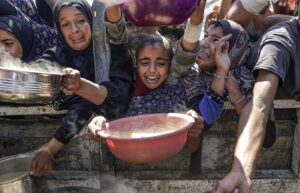 Palestinos desplazados internamente, incluidos niños, sostienen ollas para recibir alimentos de una cocina de caridad, en la ciudad de Gaza, el 4 de agosto de 2025. EFE/EPA/MOHAMMED SABER