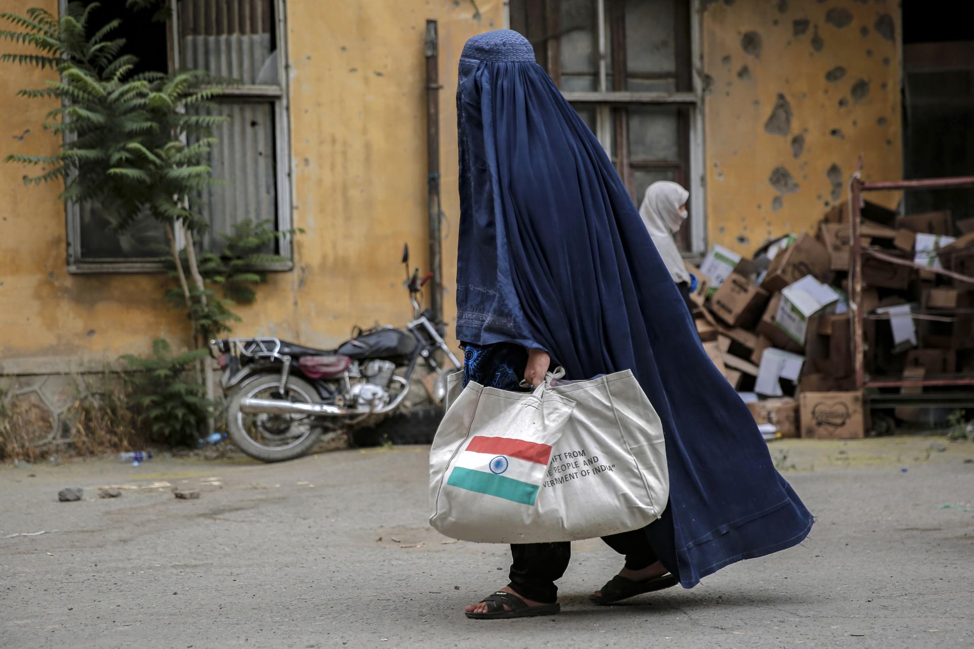 Una mujer refugiada afgana recibe una ración donada por el gobierno indio, en Kabul, Afganistán, 01 de agosto de 2025. La distribución de ayuda donada por la India comenzó en Kabul para las familias de retornees afganos como parte de una iniciativa más grande por parte del Ministerio de Refugiados y Repatriaciones, ya que casi dos millones de refugiados afganos han sido deportados por la fuerza en los últimos meses, principalmente de Irán, Pakistán y Turquía. (Afganistán, Turquía) EFE/EPA/SAMIULLAH POPAL
