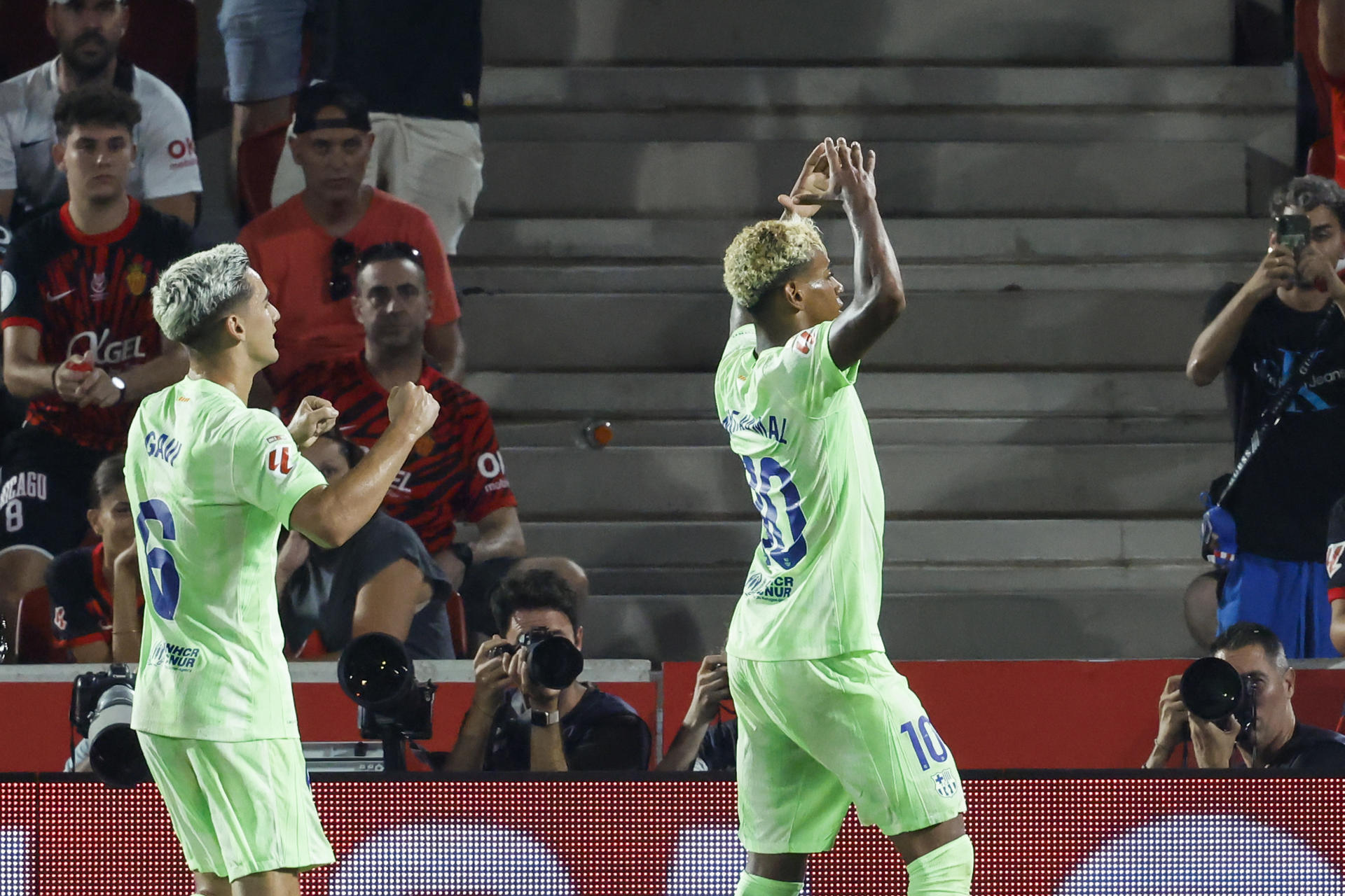 El delantero del FC Barcelona Lamine Yamal (d) celebra un gol con su compañero Gavi durante el partido de este sábado frente al Mallorca. EFE/ Cati Cladera