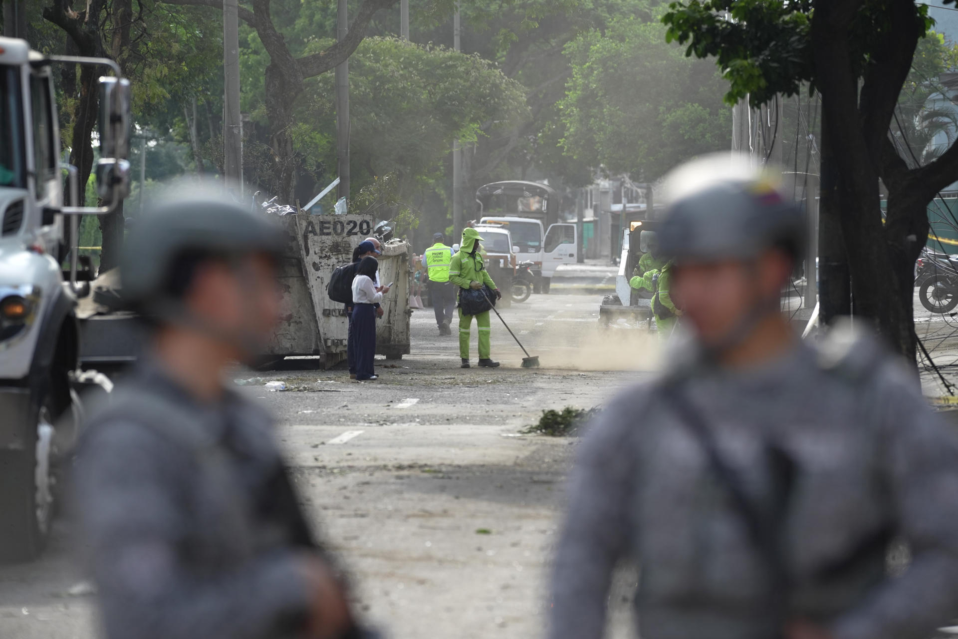 Personal de aseo recoge escombros en una calle cercana a la Escuela Militar de Aviación Marco Fidel Suárez este viernes, en Cali (Colombia). EFE/ Ernesto Guzmán