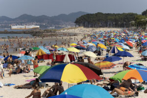 Decenas de personas disfrutan de la Playa de Samil en Vigo, este domingo. La niebla ha dado un respiro a la Ría de Vigo y hoy se ha visto plagada de bañistas tanto españoles como portugueses. EFE / Salvador Sas