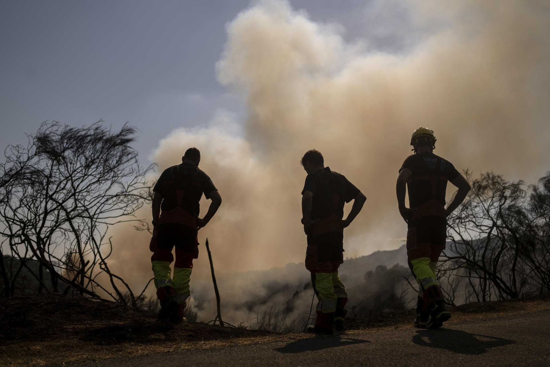 Varios bomberos durante las labores de extinción del incendio que afecta al municipio ourensano de Vilardevós y que, según las últimas estimaciones de la Xunta, que ha decretado el nivel 2 de emergencia por su proximidad a núcleos de población, afecta a 400 hectáreas. EFE/ Brais Lorenzo