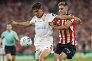 El defensa del Sevilla Juanlu (i) lucha con Robert Navarro, del Athletic de Bilbao, en San Mamés. EFE/Miguel Toña