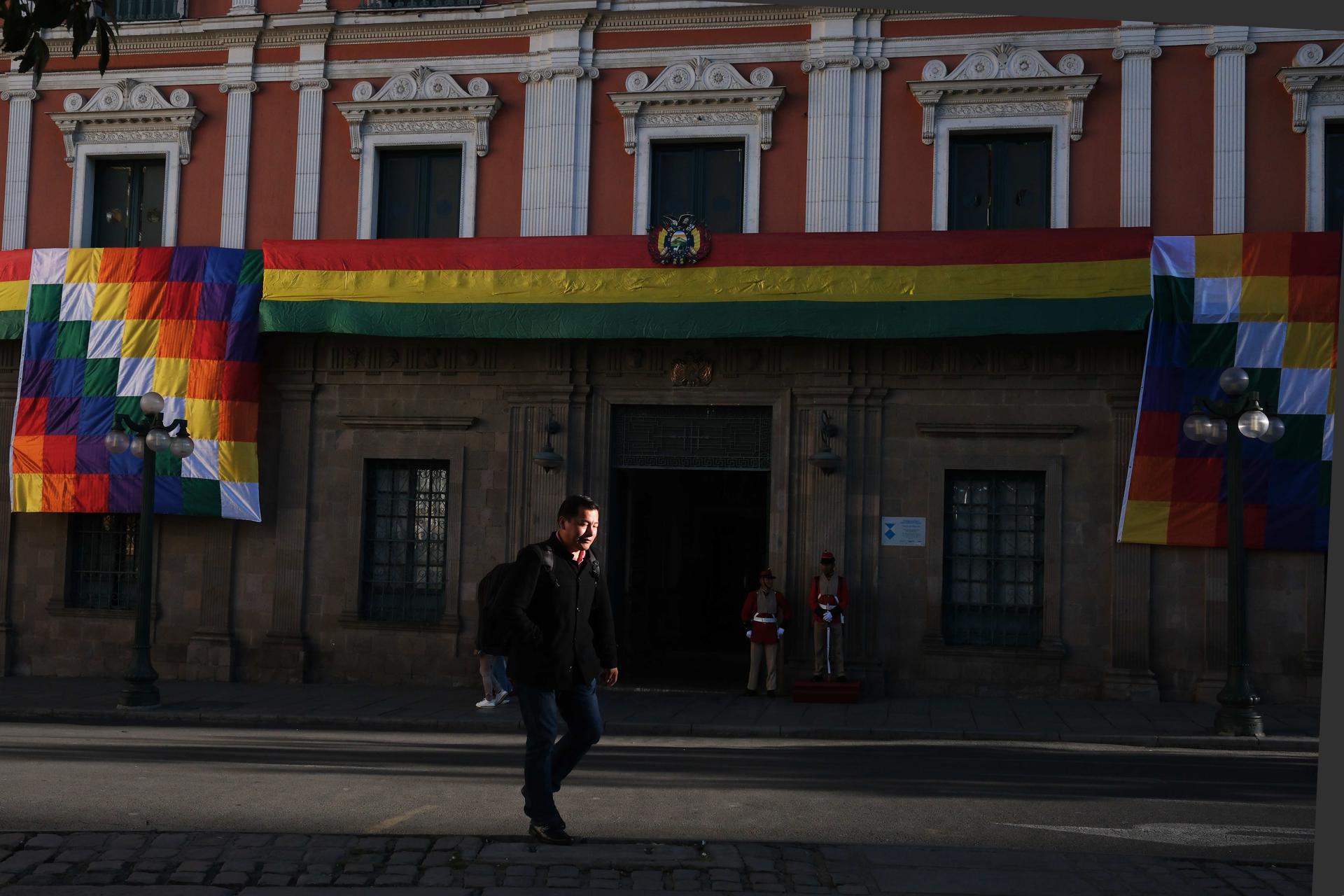 Una persona camina frente al Palacio de Gobierno adornado con banderas de Bolivia este lunes, en La Paz (Bolivia). EFE/Luis Gandarillas