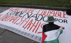 Una persona realiza un cartel contra el expresidente Álvaro Uribe este viernes, frente al Complejo Judicial de Paloquemao en Bogotá (Colombia). EFE/ Mauricio Dueñas