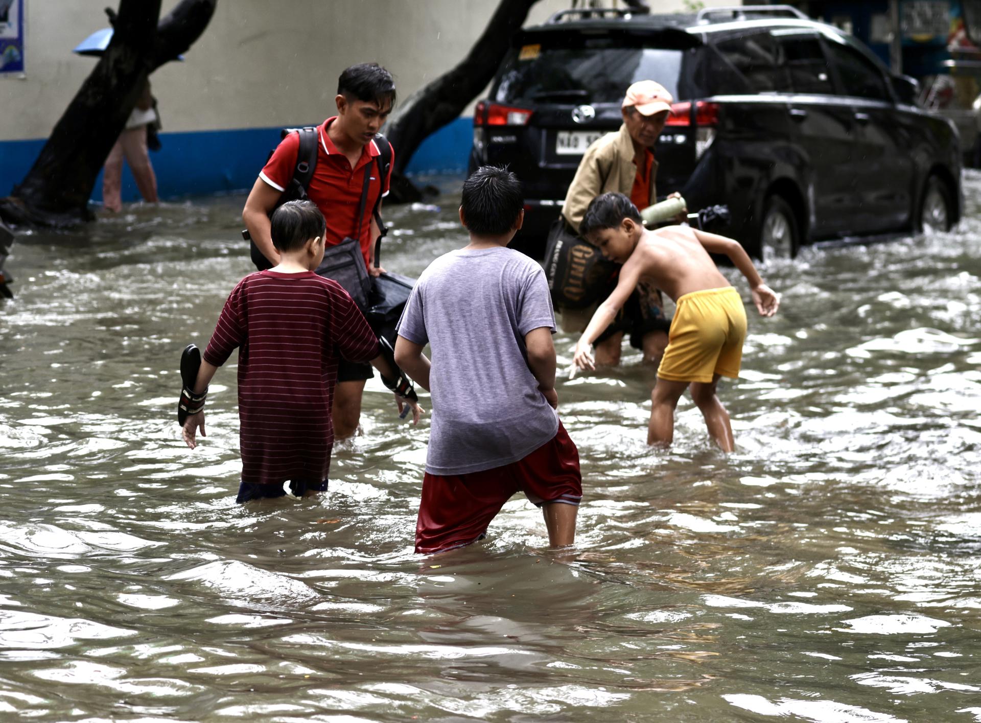 MANILA (Filipinas), 22/08/2025.- Filipinos atraviesan inundaciones en una carretera en Manila, Filipinas, el 22 de agosto de 2025, causadas por una depresión tropical acompañada de vientos de hasta 90 kilómetros por hora. EFE/EPA/FRANCIS R. MALASIG

