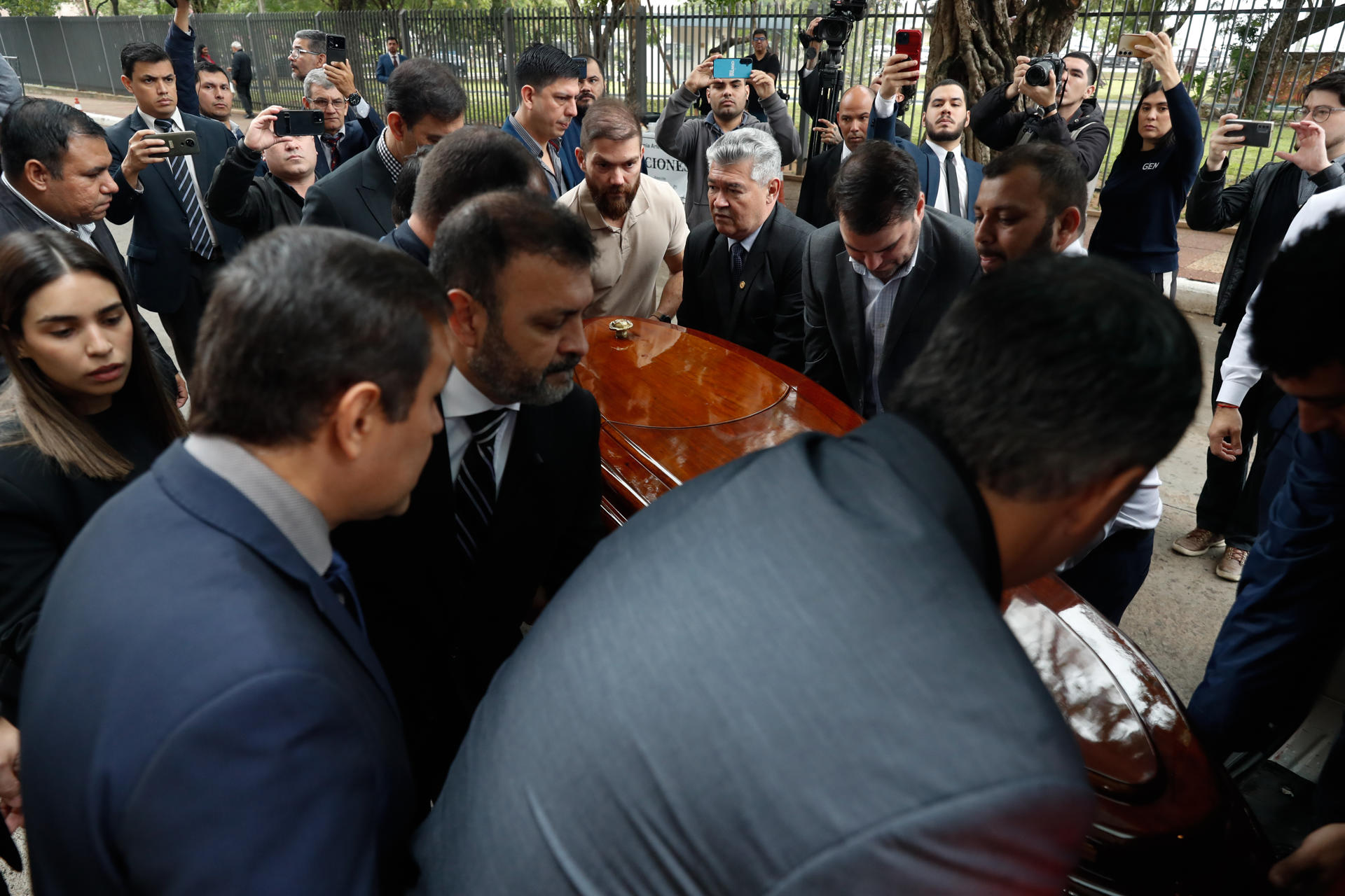 Personas sostienen el féretro del diputado oficialista Derlis Rodríguez, durante un homenaje póstumo este martes, en el Palacio Legislativo en Asunción (Paraguay). EFE/ Juan Pablo Pino