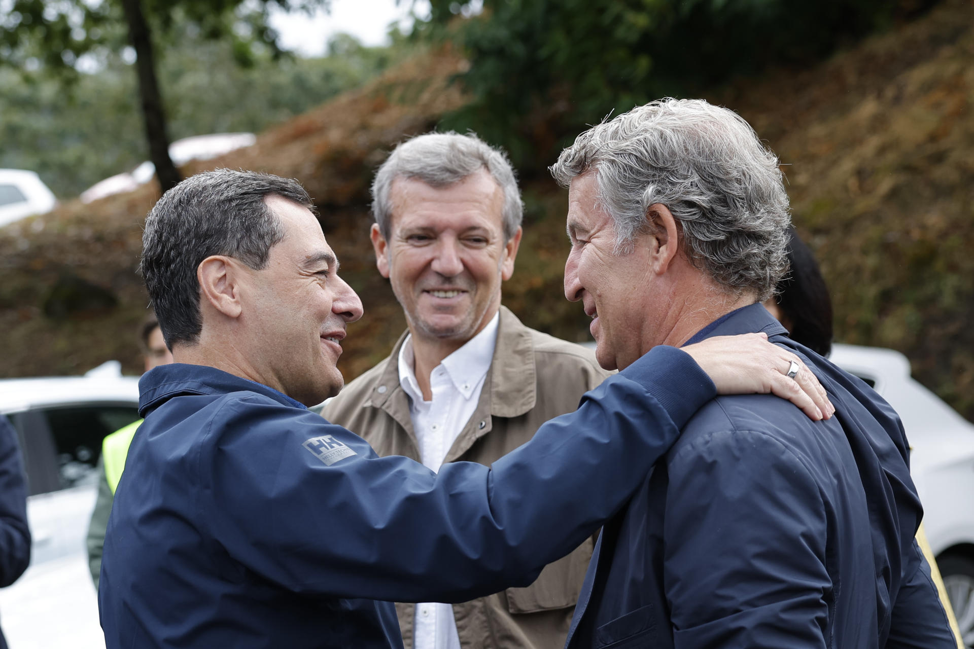 El líder del PP, Alberto Núñez Feijóo (d), saluda al presidente de la Junta de Andalucía, Juanma Moreno (i), en presencia del presidente de la Xunta de Galicia, Alfonso Rueda (c), a su llegada al acto de inauguración de la temporada política este domingo en la localidad pontevedresa de Cerdedo-Cotobade. EFE/ Lavandeira Jr
