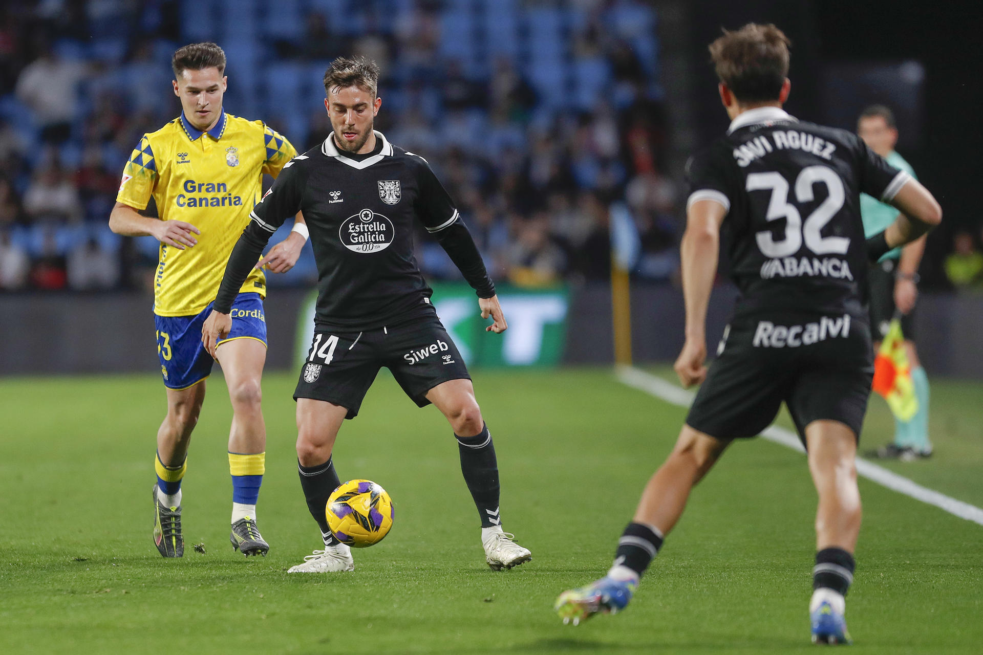 El delantero del Celta Iker Losada (c) pelea por un balón ante el defensa de Las Palmas Mika Mármol (i) el estadio de Balaidos en Vigo (Galicia) en foto de archivo de Salvador Sas. EFE