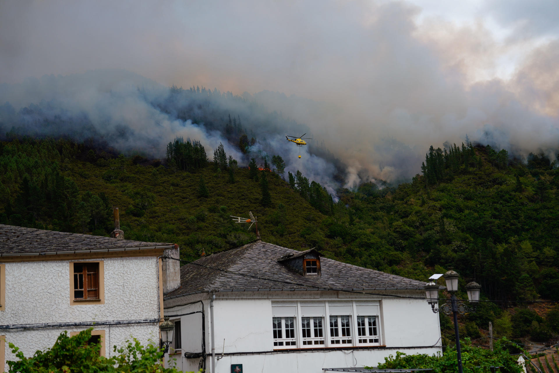 Un helicóptero en labores de extinción del incendio que afecta a los alrededores de San Antolín de Ibias, este miércoles. EFE/Paco Paredes