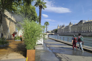 Imagen de archivo de varias personas refrescándose en unos aspersores de agua fría en París. EFE/Edgar Sapiña Manchado