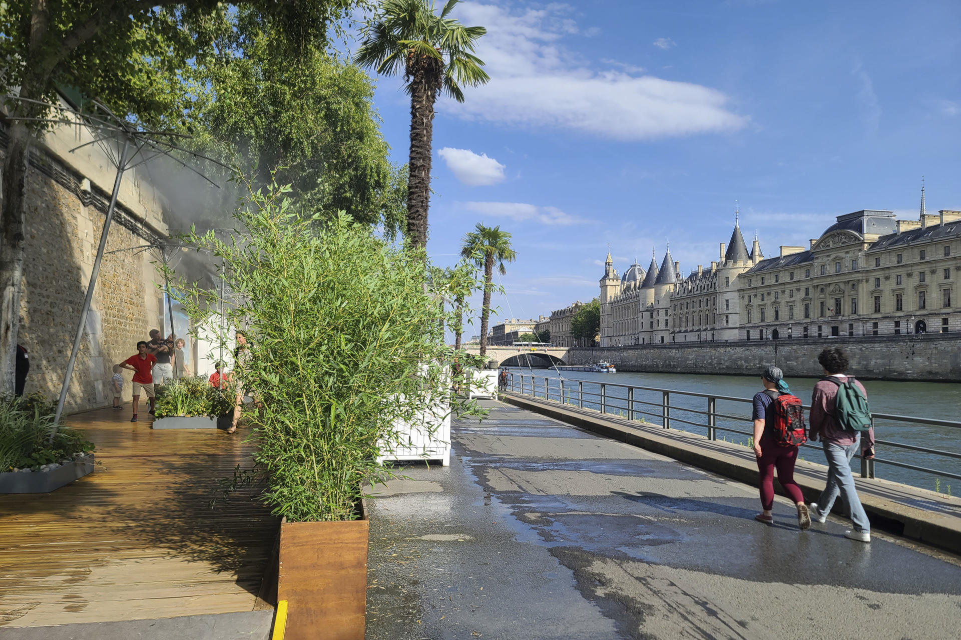 Imagen de archivo de varias personas refrescándose en unos aspersores de agua fría en París. EFE/Edgar Sapiña Manchado