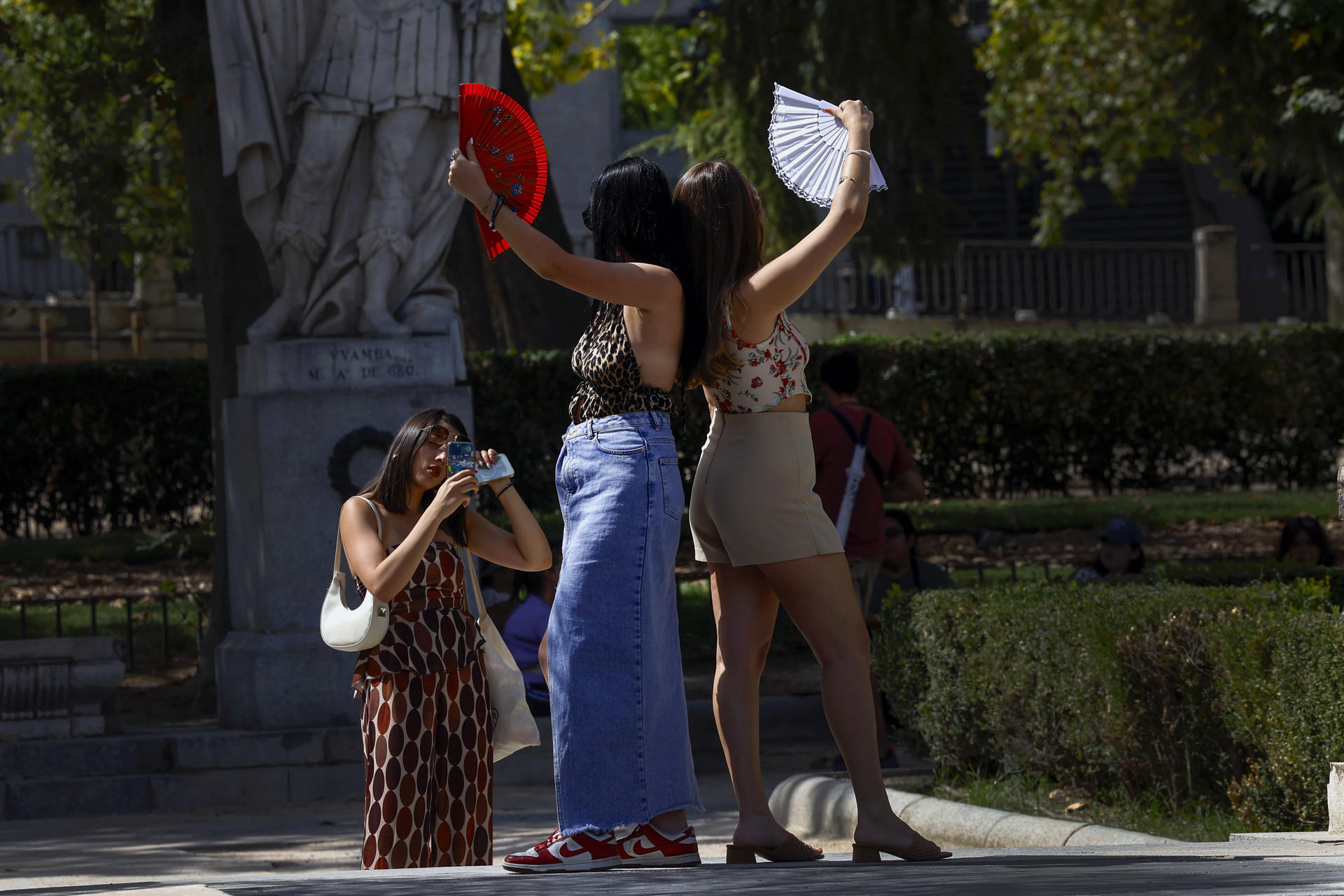 Turistas en la Plaza de Oriente en Madrid este miércoles. La persistente ola de calor que mantiene en vilo a España alcanza este miércoles el 'ecuador' de este episodio térmico, con un ligero alivio en las temperaturas en gran parte del territorio.-EFE/Chema Moya