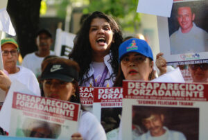 Familiares de víctimas de desaparición forzada protestan este sábado sosteniendo carteles con fotos de sus allegados desaparecidos, en Cúcuta (Colombia). EFE/Mario Caicedo