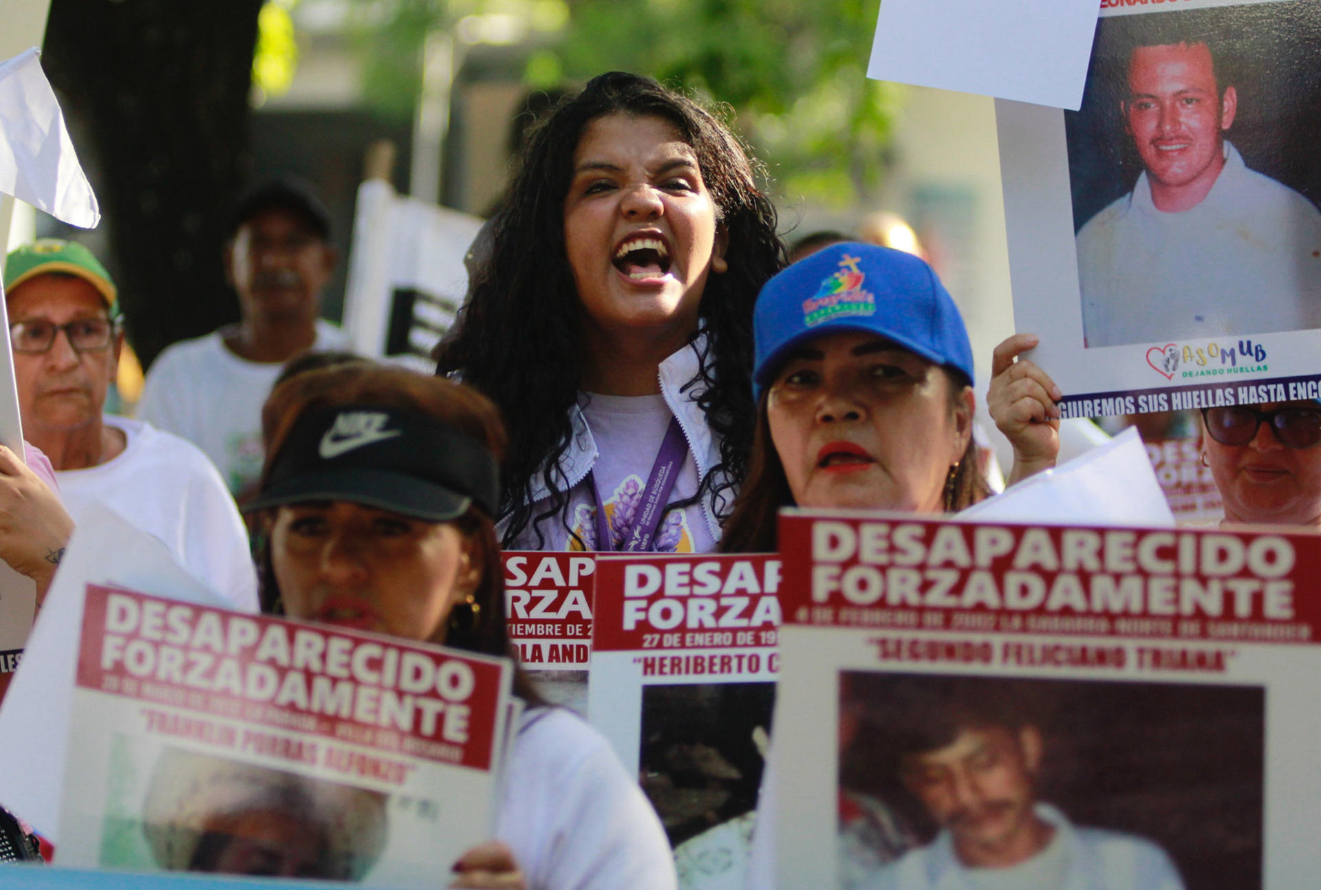Familiares de víctimas de desaparición forzada protestan este sábado sosteniendo carteles con fotos de sus allegados desaparecidos, en Cúcuta (Colombia). EFE/Mario Caicedo