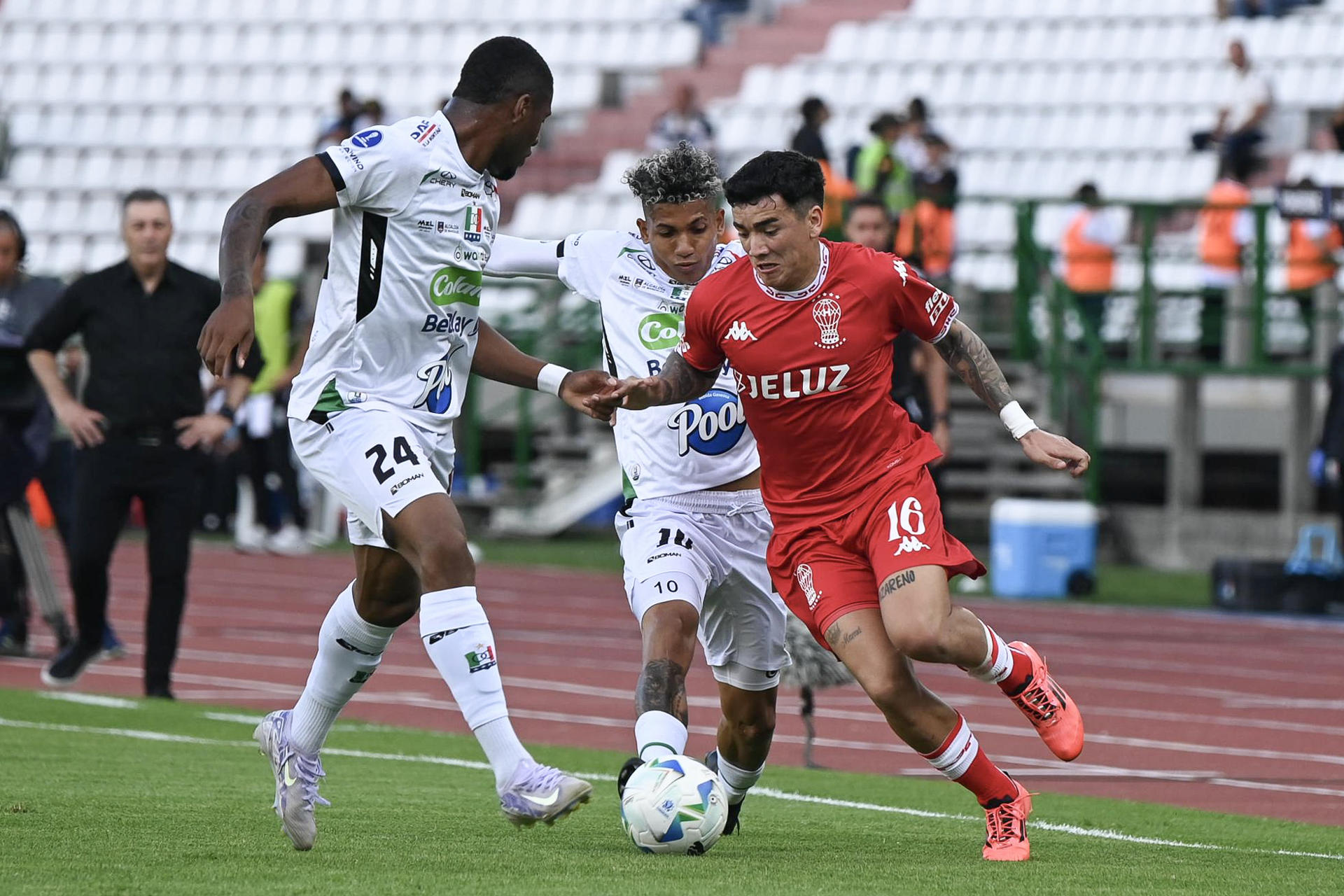 Luis Ángel Palacios (i) y Luis Sánchez (c) de Once Caldas disputan el balón con Rodrigo Cabral de Huracán este martes, durante un partido de octavos de final de la Copa Sudamericana. EFE/ Agencia Unido360
