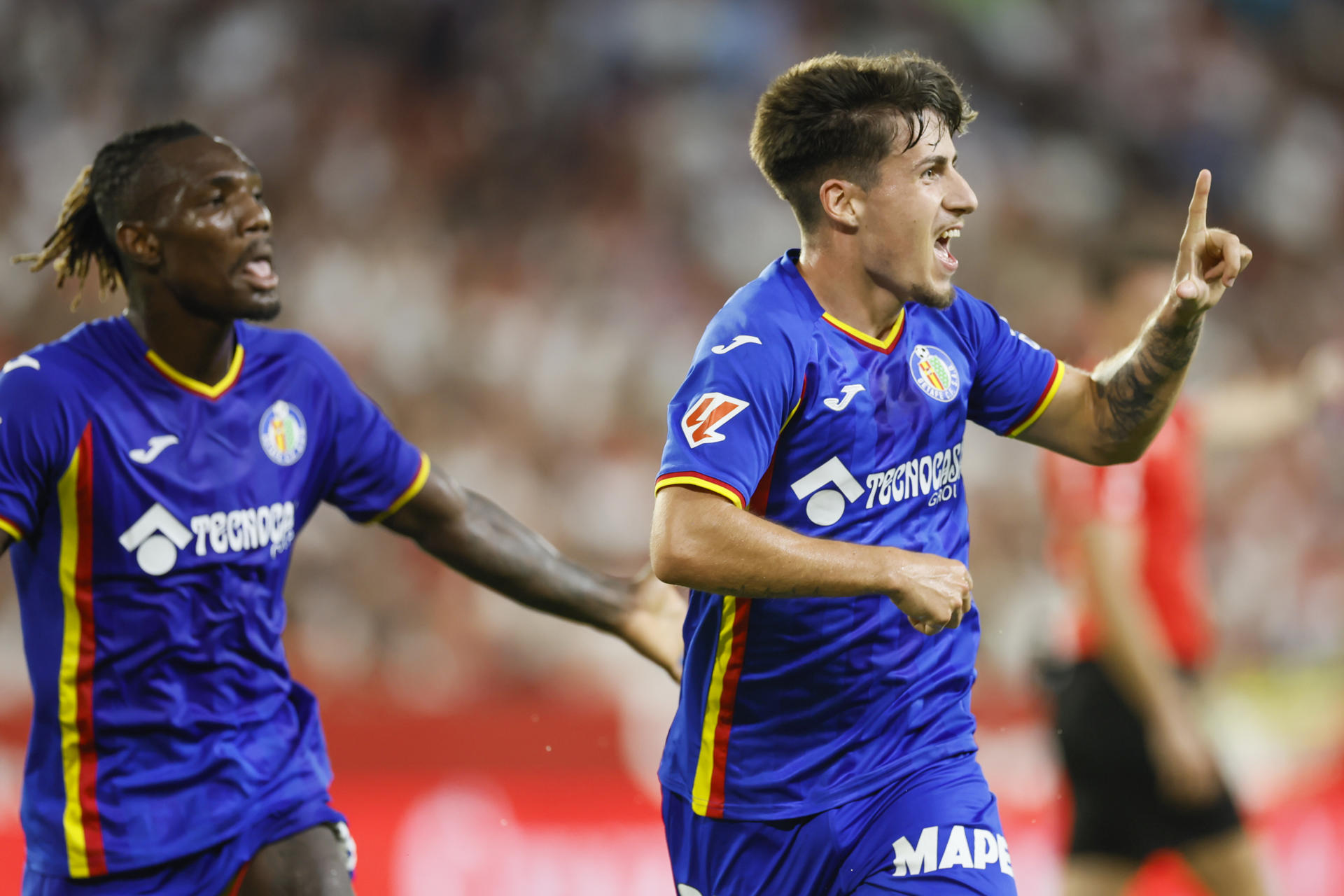 El delantero del Getafe Adrián Liso celebra tras marcar el 0-1 durante el partido correspondiente a la segunda jornada de LaLiga EA Sports entre Sevilla y Getafe disputado este lunes en el estadio Sánchez Pizjuán de Sevilla. EFE/José Manuel Vidal