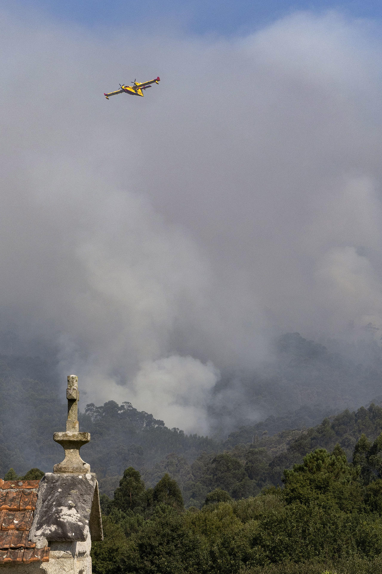 Un hidroavión descarga agua sobre el incendio de Vilaboa, con 50 hectáreas ardidas, donde se mantiene la situación 2 por la proximidad al núcleo de Vilar, en Santa Cristina de Cobres.EFE/ Salvador Sas