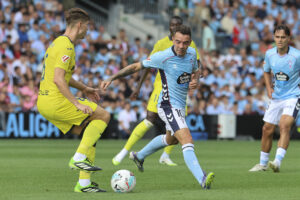 El delantero del Celta de Vigo Iago Aspas (c) presiona al defensa argentino del Villarreal Juan Foyth (i) en el partido de LaLiga disputado este domingo en el estadio Balaidos de Vigo. EFE / Salvador Sas