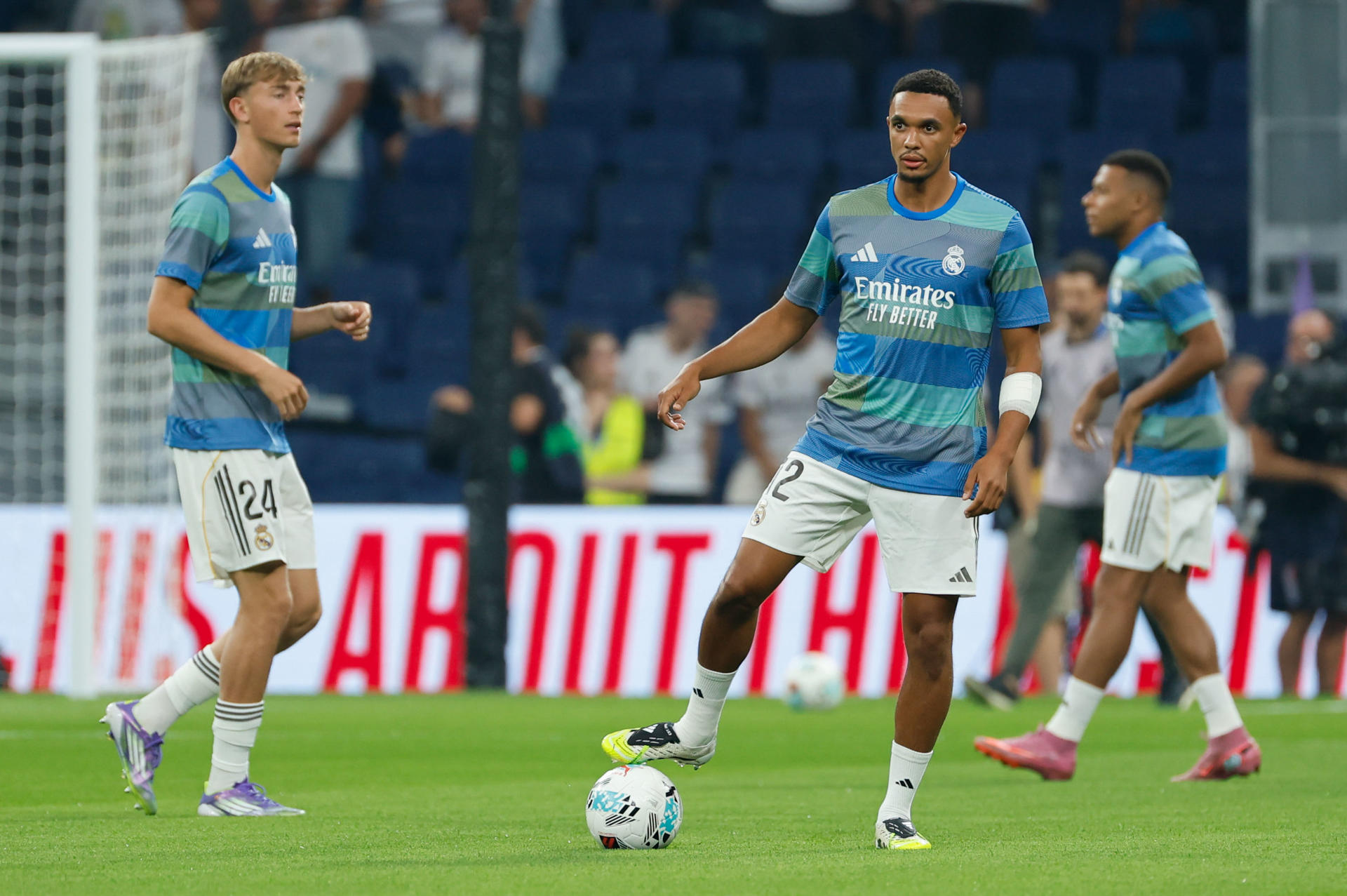 El defensa británico del Real Madrid Trent Alexander-Arnold calienta antes del partido de la primera jornada de LaLiga que Real Madrid y Atlético Osasuna disputan hoy martes en el estadio Santiago Bernabéu de Madrid. EFE/ Mariscal