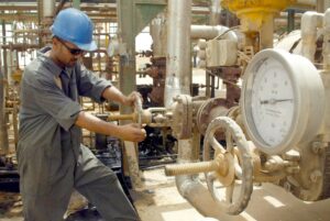 Un operario abre una válvula en una refinería de petróleo de Najaf, en Irak. EFE/Hussein Al-Mousawi