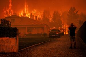 Un hombre observa cómo un incendio forestal se desata cerca de una casa en Granja do Paiva, municipio de Sernancelhe, distrito de Viseu, Portugal, el 14 de agosto de 2025. 
EFE/EPA/PEDRO SARMENTO COSTA