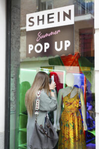 Fotografía de archivo de una mujer observando los diseños del escaparate de un establecimiento de la firma china de moda Shein. EFE/Luis Millán