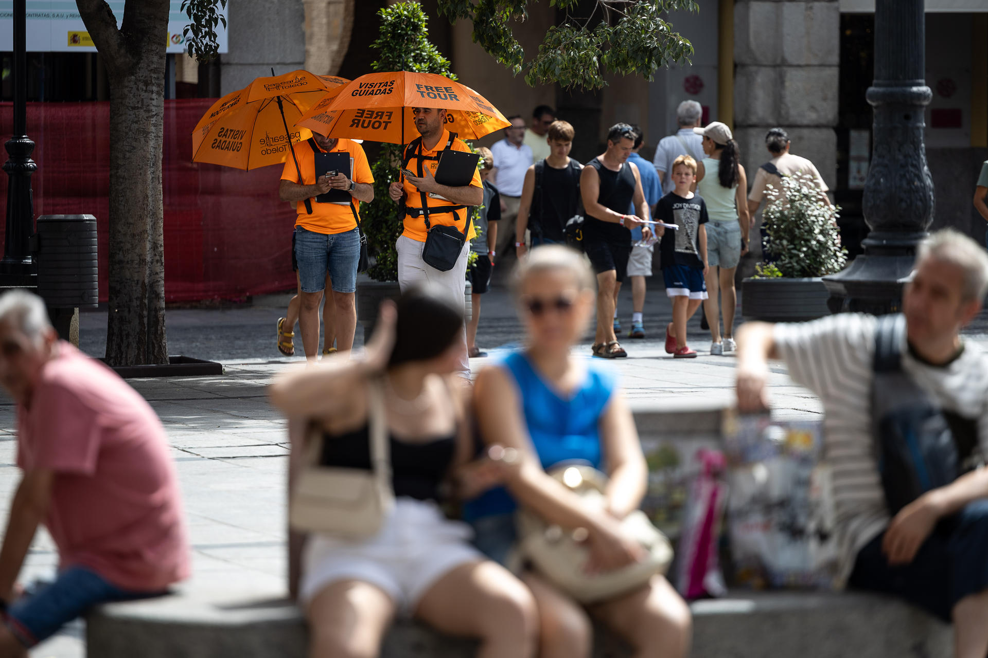 Guías que ofrecen visitas a cambio de la voluntad de los usuarios aguardan a su próximo grupo de visitantes por el centro de Toledo. La ordenanza municipal, pionera, de Toledo para regular la actividad turística y la convivencia ciudadana, que está en fase de información pública y tiene previsto aprobarse en el pleno de septiembre, cuenta con el apoyo de la Asociación de Guías de Turismo Castilla-La Mancha y de los vecinos, aunque los guías 'free tour' han iniciado una recogida de firmas en contra de esta normativa municipal. EFE/ Ismael Herrero