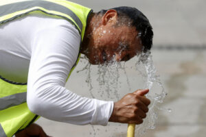 Un trabajador se refresca con una manguera en una calle de Madrid. EFE/ Juan Carlos Hidalgo