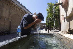 Un turista se refresca en una fuente en Córdoba. EFE/Salas