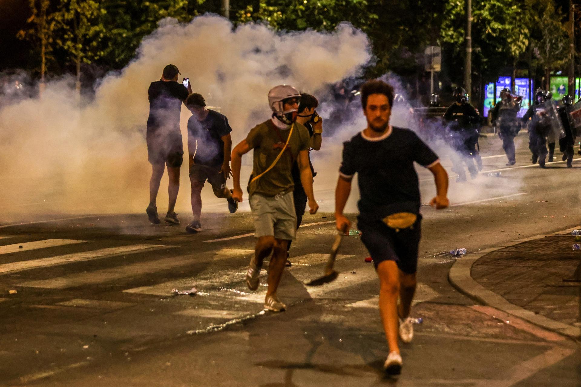 Manifestantes fueron captados este jueves, 14 de agosto, al enfrentarse a agentes de la Policía, durante una nueva jornada de protestas antigubernamentales, en Belgrado (Serbia). EFE/Andrej Cukic
