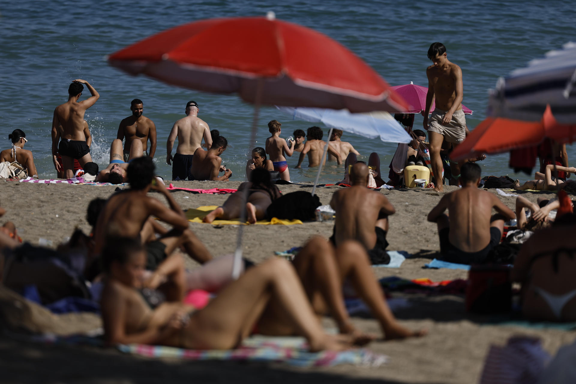 Muchas personas en la playa de la Malagueta este jueves en Málaga en el que continúa la ola de calor. EFE/Jorge Zapata