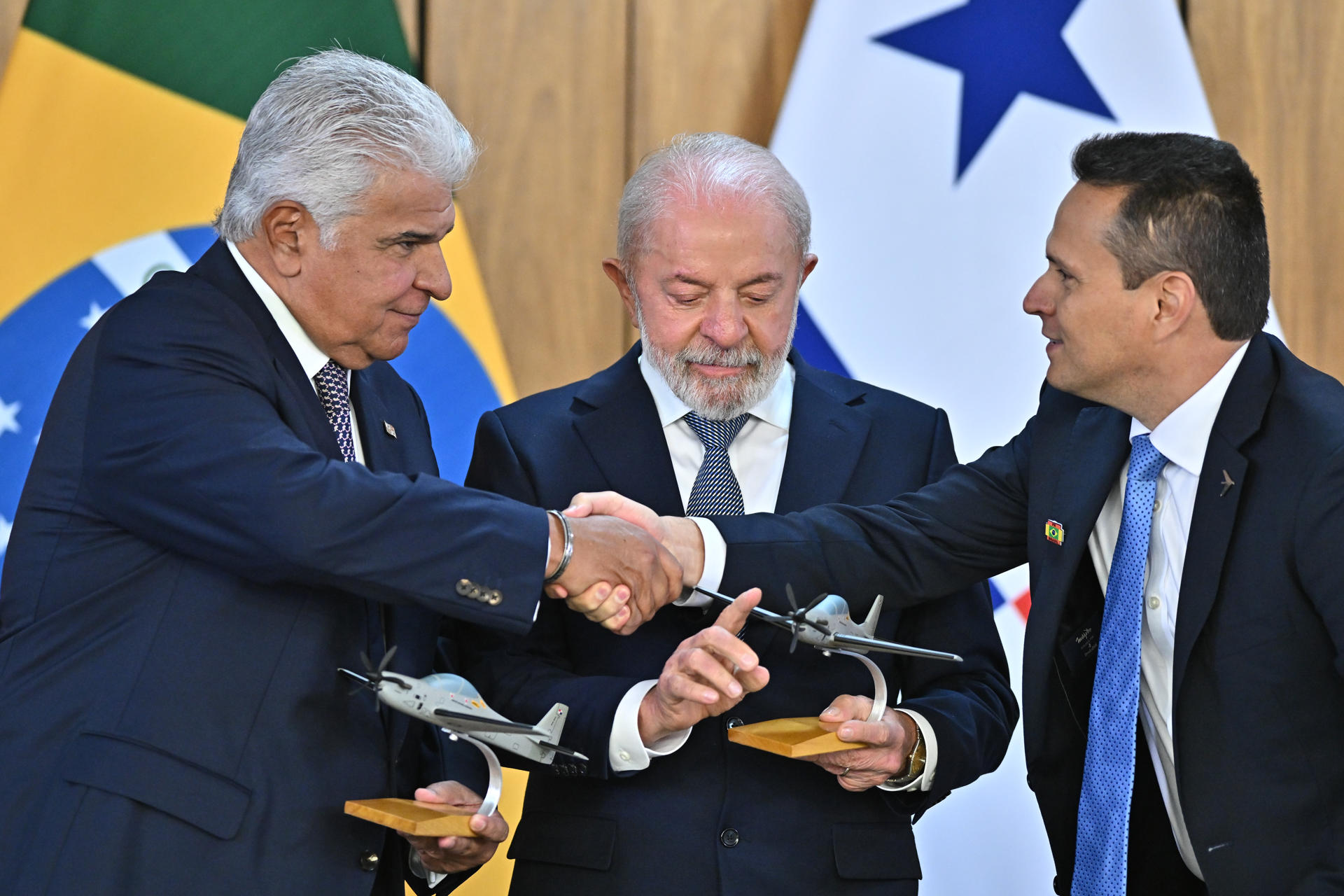 El presidente de Brasil, Luiz Inácio Lula da Silva (c) y su homólogo de Panamá, José Raúl Mulino (i), acompañados por el presidente de la compañía Embraer - Defence & Security, João Bosco Costa (d), sostienen miniaturas de aeronaves durante una rueda de prensa este 28 de agosto de 2025, en el Palacio del Planalto en Brasilia (Brasil). EFE/Andre Borges