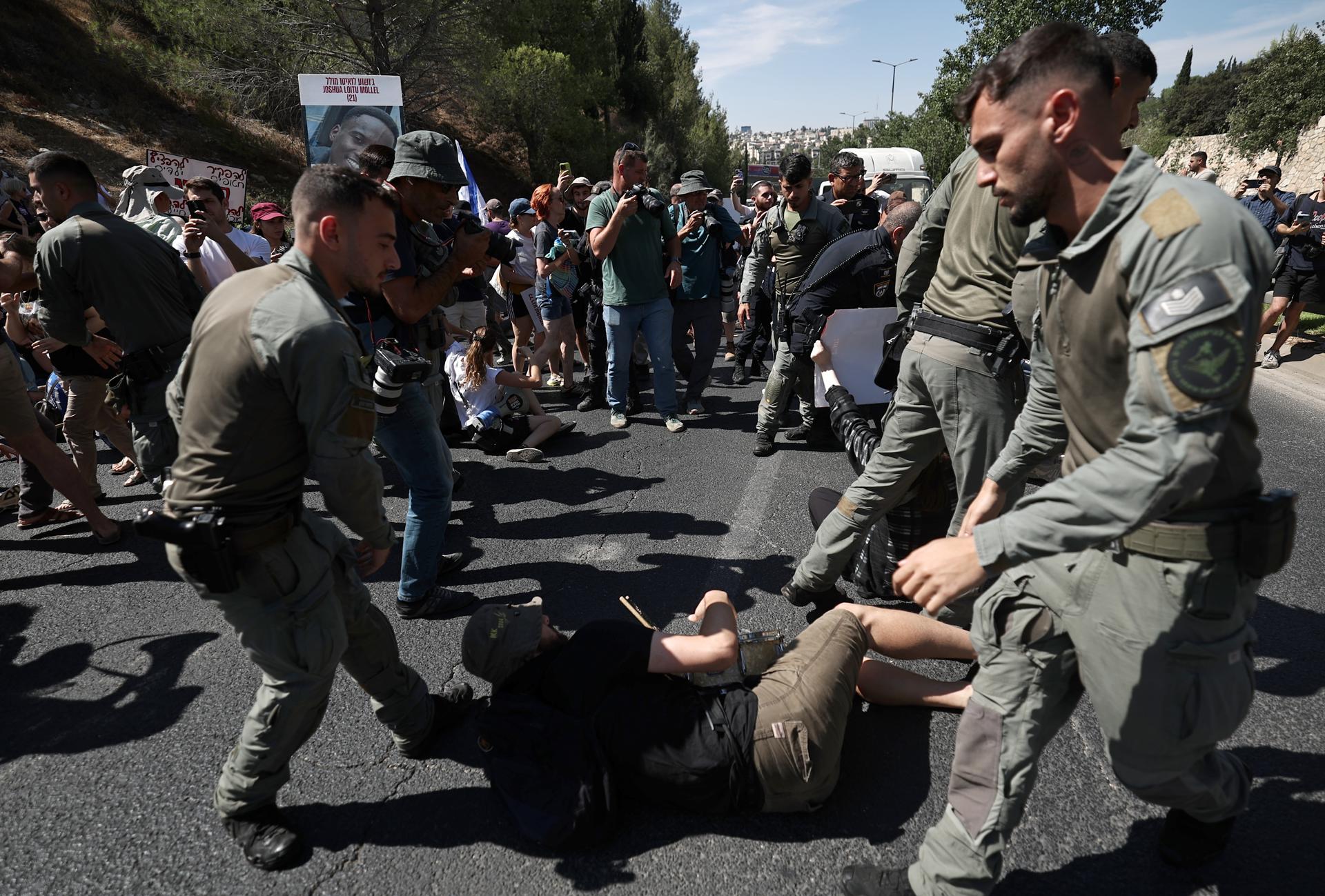 Agentes de policía israelíes intentan retirar a los manifestantes que bloquearon una carretera principal en Jerusalén, este domingo 17 de agosto de 2025. La protesta forma parte de una huelga nacional para exigir la liberación inmediata de los rehenes retenidos por Hamás y para pedir al gobierno israelí que detenga la guerra en Gaza. (Protestas, Jerusalén) EFE/EPA/ATEF SAFADI