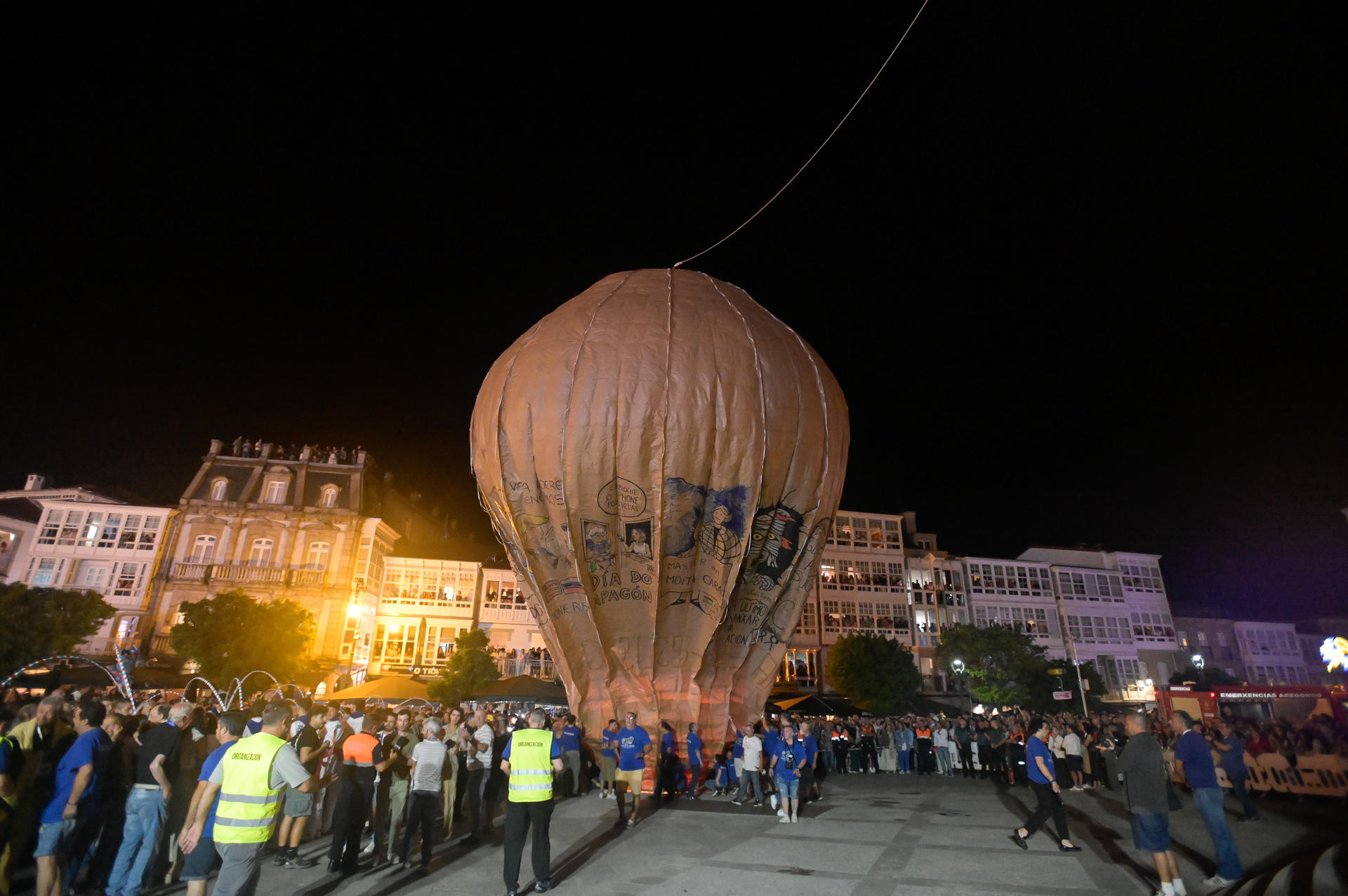 El globo de papel más grande del mundo, en Betanzos (A Coruña), ha vuelto a despegar este San Roque para cumplir 150 años con un currículum intachable y una ácida crítica a los expedientes falsificados de algunos políticos. La tradición establece que en el aerostato van diseños sobre cuestiones actuales y, en esta ocasión, las críticas a los currículums falsificados de algunos políticos han sido protagonistas. EFE/Moncho Fuentes
