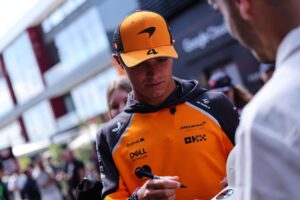 El piloto británico de McLaren Lando Norris firma un autógrafo antes de los entrenamientos libres del Gran Premio de Hungría de Fórmula 1. EFE/EPA/ANNA SZILAGYI