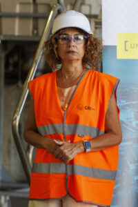 La vicepresidenta primera del Gobierno y ministra de Hacienda, María Jesús Montero, con casco y gafas protectoras, durante la visita realizada este viernes a las instalaciones de la empresa GRI Towers, dedicada a la fabricación de componentes para turbinas eólicas, en la Zona Franca de Sevilla. EFE/ Julio Muñoz