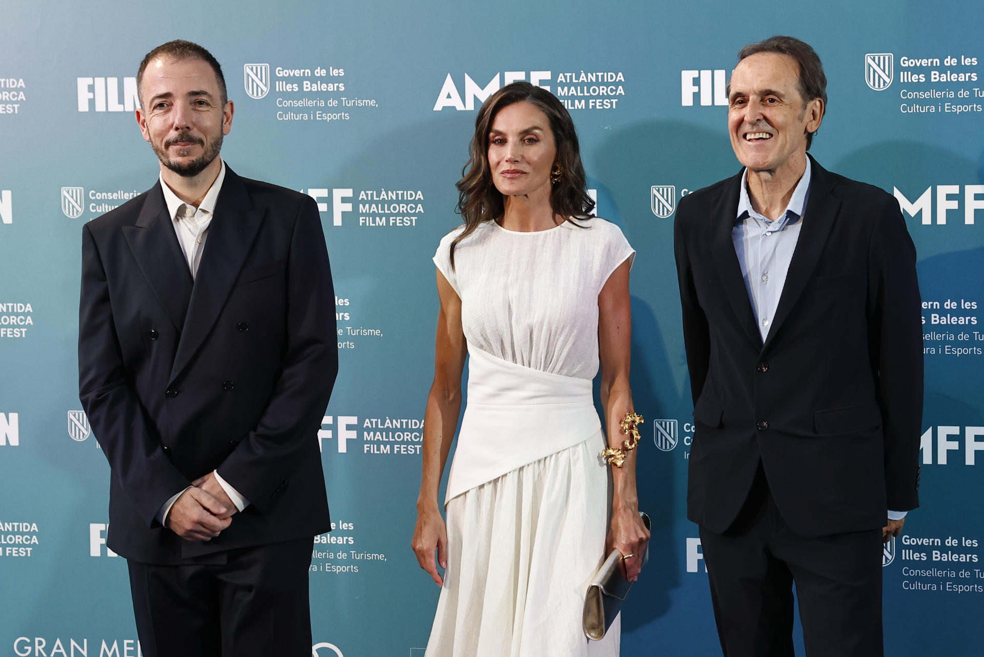La reina Letizia junto al director del Atlántida Mallorca Film Festival, Jaume Ripoll (i) y el compositor Alberto Iglesias (d) a su llegada a la gala de clausura del festival cinematográfico, este domingo en Palma, y donde Iglesias recibirá el premio Master of Cinema. EFE/Ballesteros
