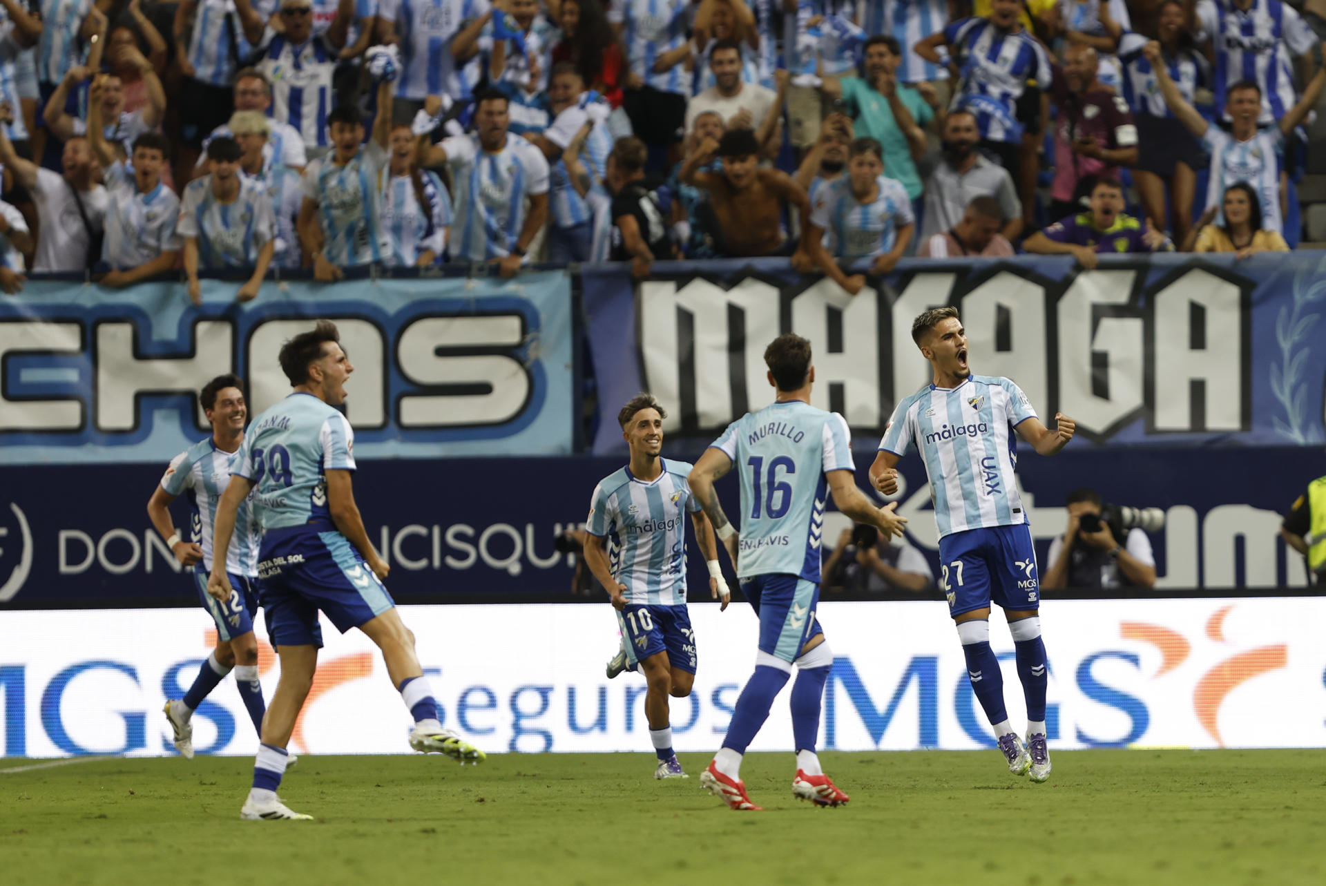 El delantero del Málaga Chupe (d) celebra tras marcar su gol durante el partido del Torneo Costa del Sol que Málaga CF y Real Betis disputan hoy sábado en el estadio de La Rosaleda. EFE/Jorge Zapata
