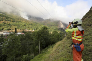 Un bombero observa un incendio este lunes en las inmediaciones de Caunedo. El cambio de las condiciones meteorológicas, con la entrada de viento norte, una mayor humedad y una notable bajada de las temperaturas, está ayudando a controlar los incendios declarados en los últimos días Asturias, donde hoy se mantienen activos ocho fuegos, en su mayoría en la comarca suroccidental y los Picos de Europa. EFE/J.L. Cereijido