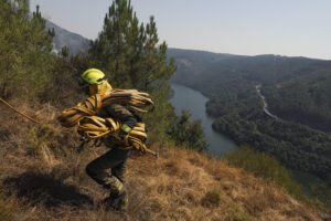 Un bombero forestal se dirige a las labores de extinción del incendio de la parroquia de A Cova (Lugo) que afecta a unas 50 hectáreas y está prácticamente bajo control. EFE/ Eliseo Trigo