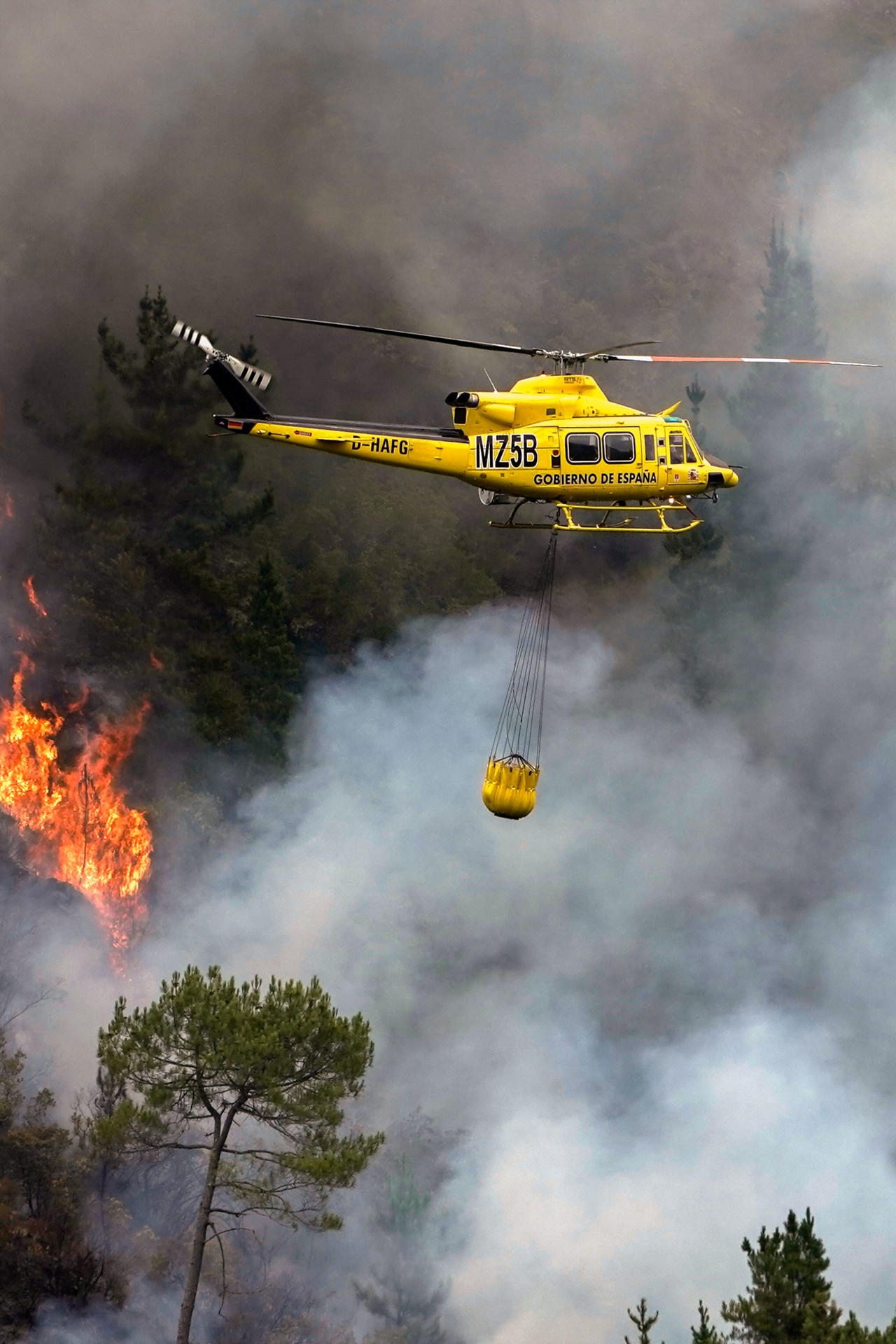 Un helicóptero en labores de extinción del incendio que afecta a los alrededores de San Antolín de Ibias este miércoles. EFE/Paco Paredes