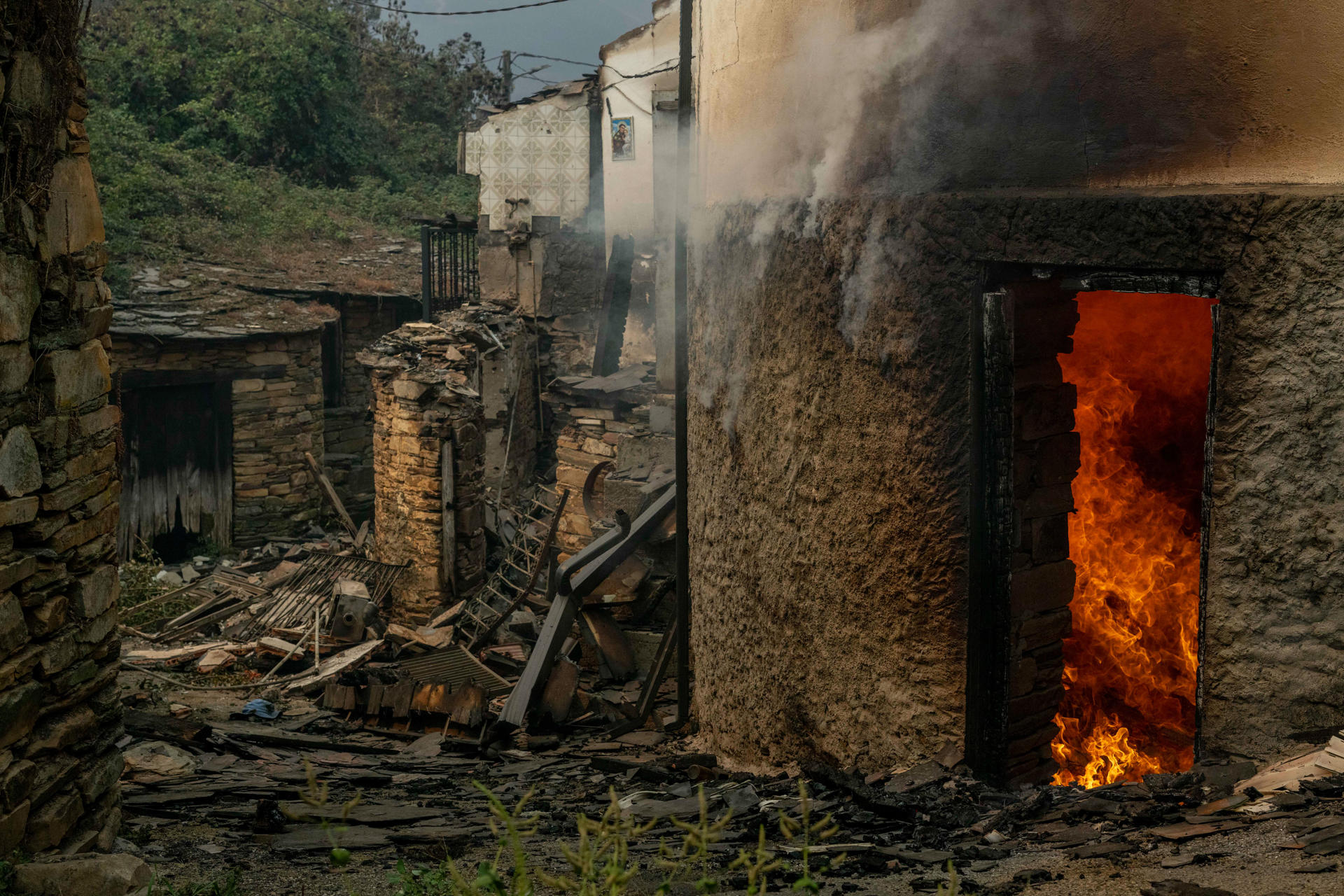 Viviendas ardiendo el lunes en la aldea de San Vicente, en Vilamartín de Valdeorras (Ourense). EFE/ Brais Lorenzo
