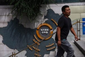 Un hombre fue captado este domingo, 24 de agosto, al caminar por el complejo Evergrande City Plaza, en Pekín (China), horas antes de que el gigante inmobiliario Evergrande Group fuera excluido de la bolsa de valores de Hong Kong. EFE/Wu Hao
