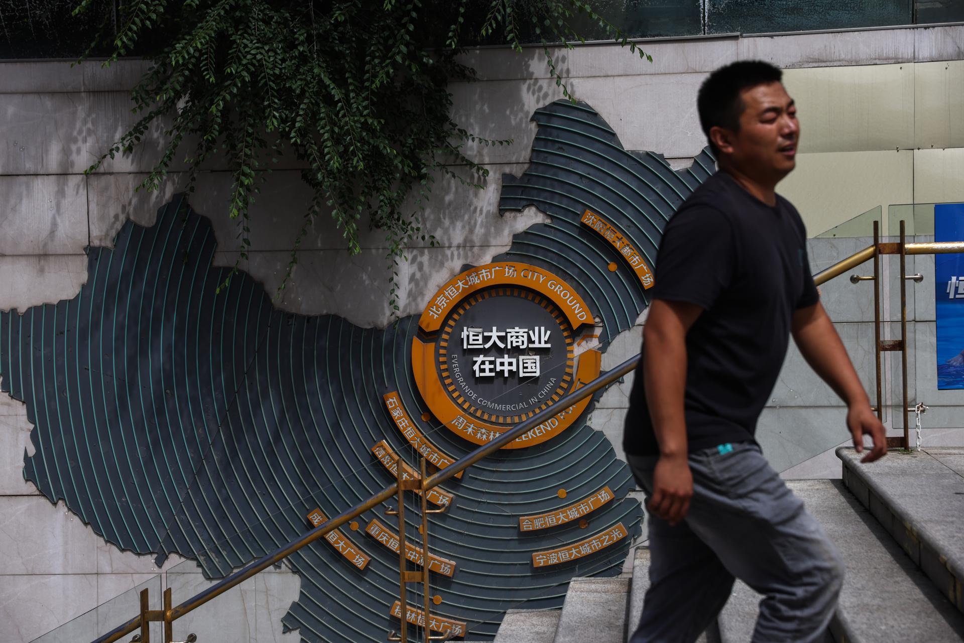 Un hombre fue captado este domingo, 24 de agosto, al caminar por el complejo Evergrande City Plaza, en Pekín (China), horas antes de que el gigante inmobiliario Evergrande Group fuera excluido de la bolsa de valores de Hong Kong. EFE/Wu Hao
